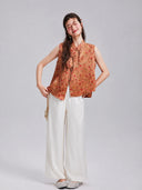 Model wearing a Gambiered Silk floral rabbit silk vest with white wide-leg trousers