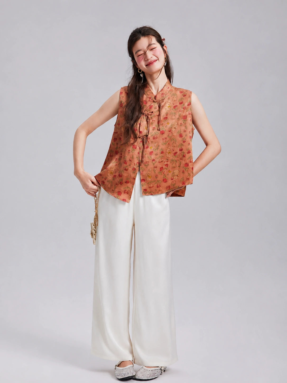 Model wearing a Gambiered Silk floral rabbit silk vest with white wide-leg trousers