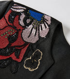 Detailed view of the red, pink, blue and black floral embroidery with sequins and bead accents
