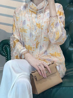 Close-up of a model wearing a floral silk-blend blouse with layered pearl necklaces