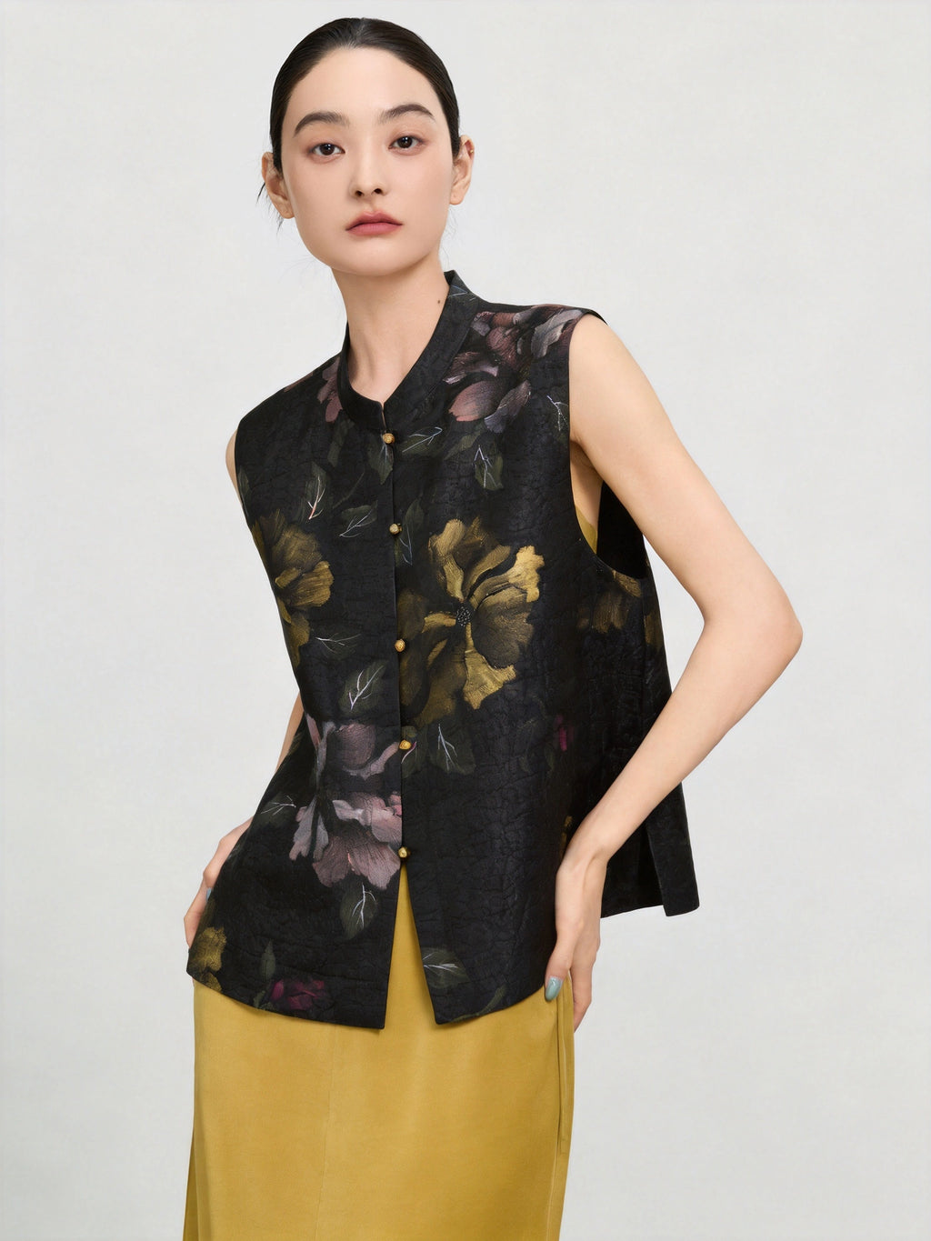 Close-up of the black mulberry silk vest featuring antique gold flowers, mauve blossoms and a stand collar.