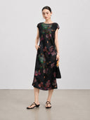 Front view of a waisted black mulberry silk dress with painterly botanical flowers.