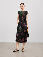 Front view of a waisted black mulberry silk dress with painterly botanical flowers.