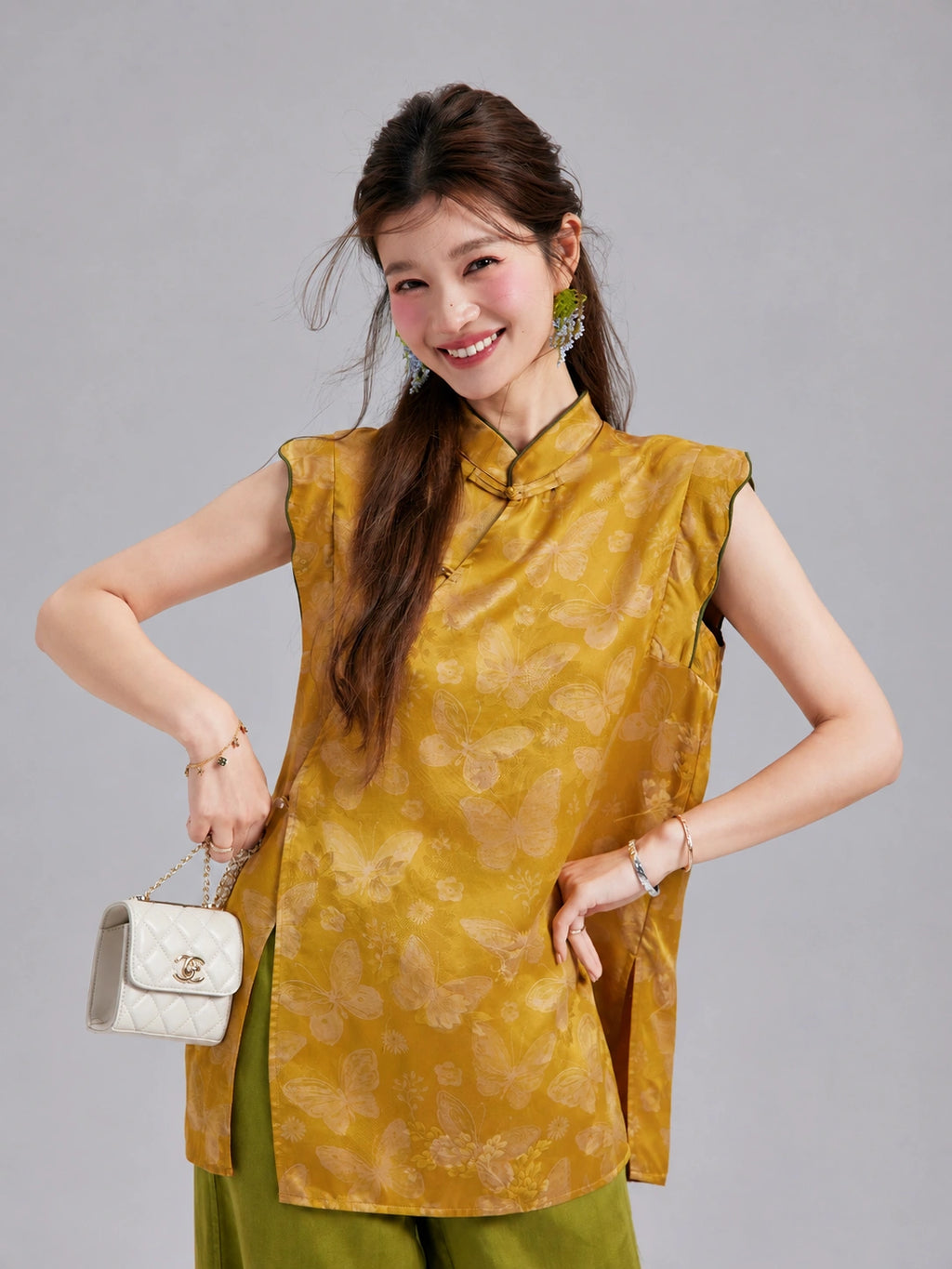 Gambiered Silk golden silk top featuring sculpted flutter shoulders, contrast piping and butterfly motifs