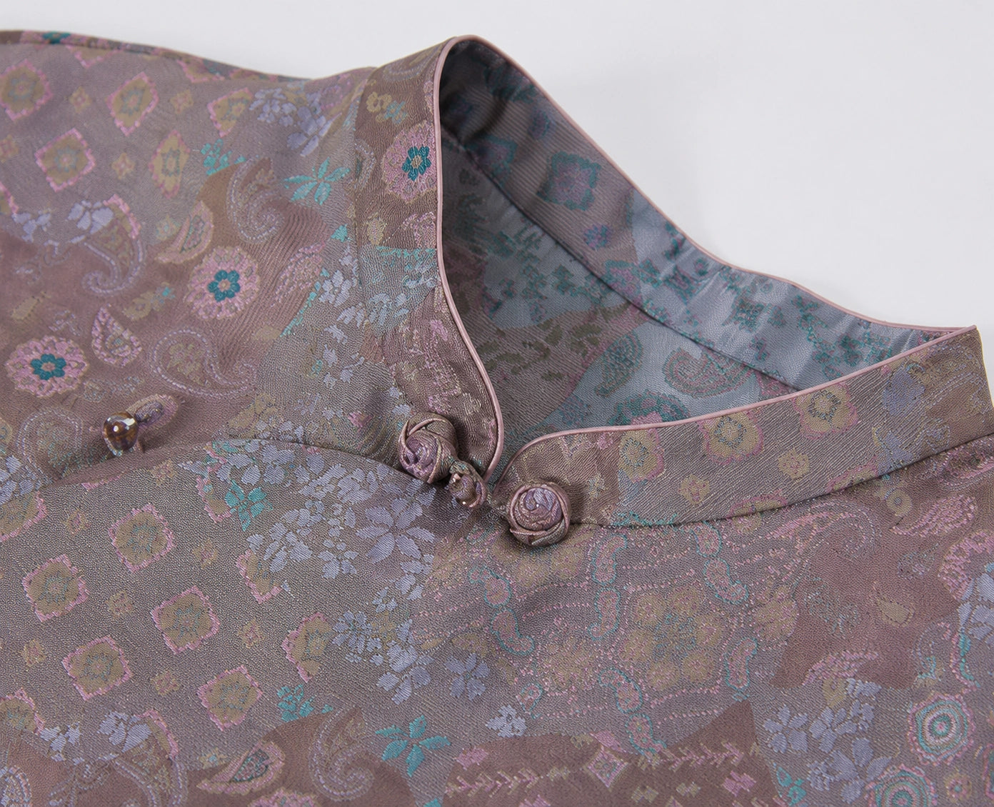 Close-up of the Mandarin collar, knotted frog buttons and intricate multicolor silk pattern.