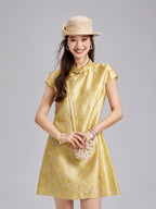 Model wearing a luminous golden Fuguang Jin silk dress with tonal botanical motifs.