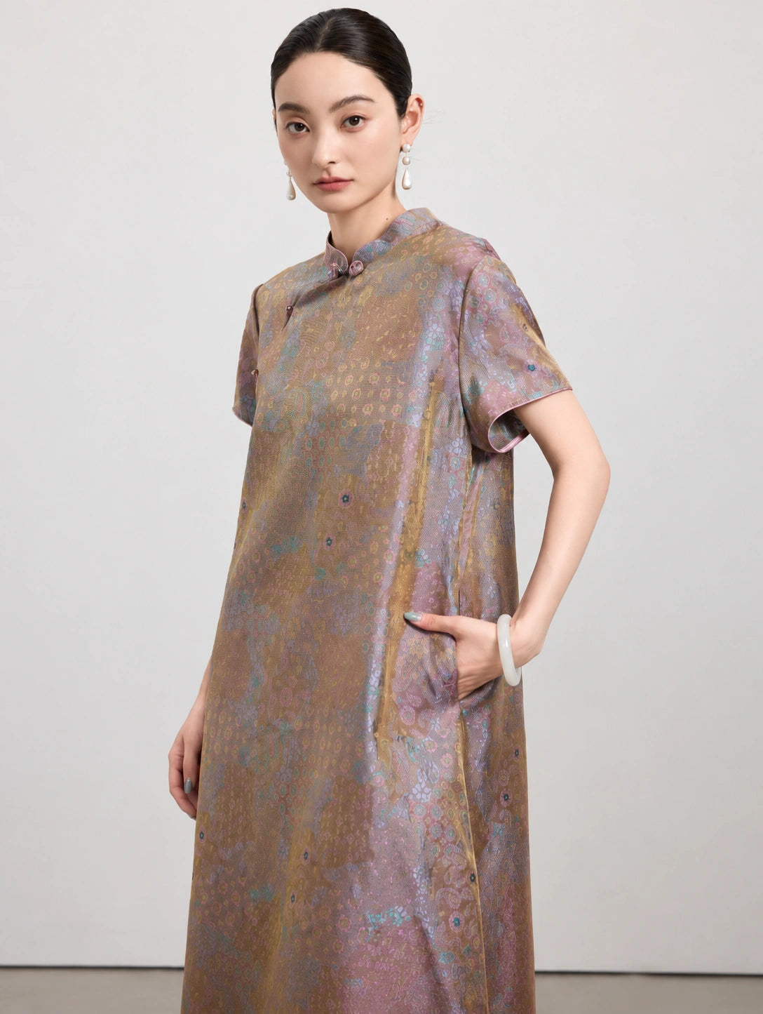 Close view of the multicolor gauze-weave silk dress showing its Mandarin collar, short sleeve and side pocket.