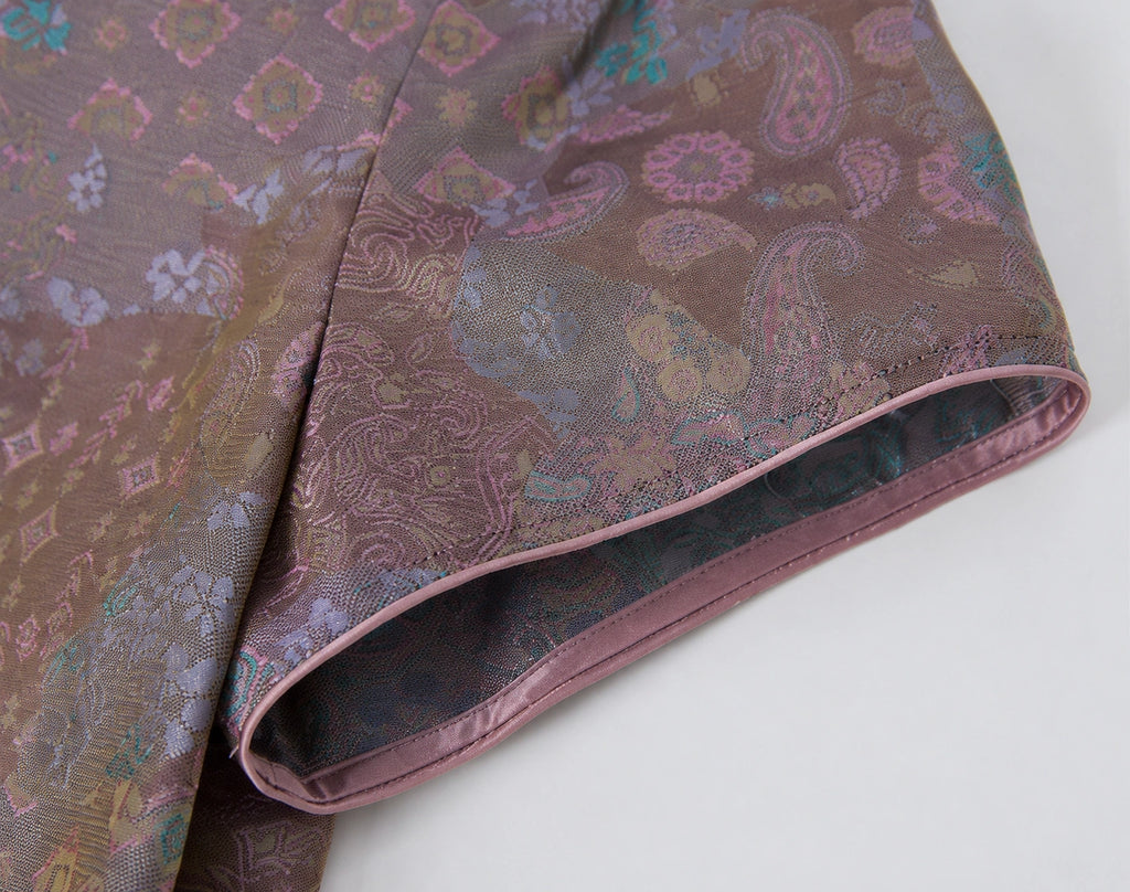 Close-up of the short sleeve and contrast piping on the patterned 100% mulberry silk dress.