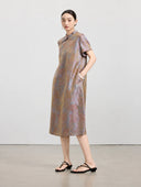 Model wearing an iridescent mauve taupe 100% mulberry silk A-line dress with a Mandarin collar and short sleeves.
