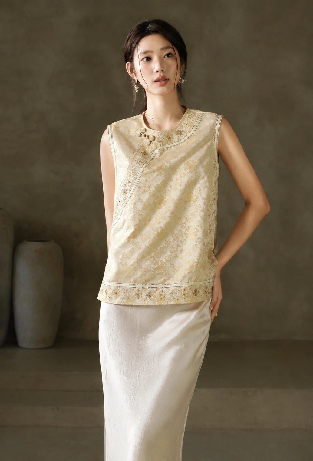 Front view of the ivory-and-gold Baoxiang floral jacquard vest styled with a white skirt
