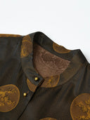 Close-up of an espresso-black silk-blend vest with a stand collar, antique-gold botanical medallions and gold-tone buttons.