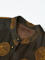 Close-up of an espresso-black silk-blend vest with a stand collar, antique-gold botanical medallions and gold-tone buttons.