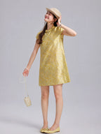 Model wearing a champagne-gold silk shift dress with short sleeves and a Mandarin collar.