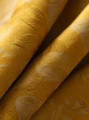 Close-up of lustrous golden mulberry silk fabric with tonal woven butterfly and floral motifs