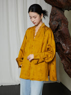 Close-up of the Golden Ochre Lyocell Lace Trim V-Neck Blouse highlighting the lace neckline, covered buttons and floral woven texture.