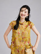Close-up of a Gambiered Silk golden rayon top with red botanical motifs, paired fish and a decorative collar closure