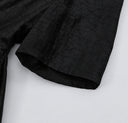 Close-up of the elbow-length sleeve and subtle crackled texture of black Hei Gui Xiangyunsha silk