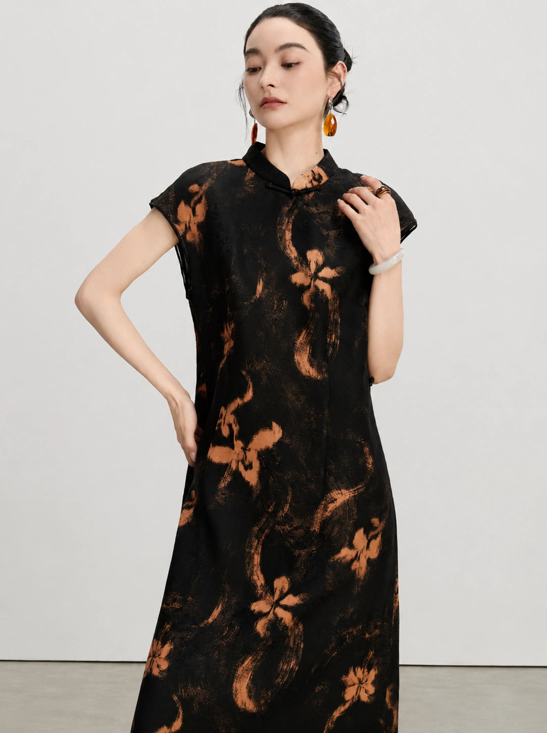 Upper-body view of the black Hua Luo silk dress with copper floral motifs and stand collar