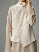 Close-up of tonal bamboo beadwork and the asymmetric front of an ivory wool and mulberry silk vest