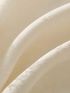 Close-up of warm-ivory polyester satin woven with subtle tonal butterfly jacquard.