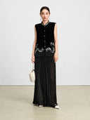 Front-facing model wearing a black silk velvet vest with ivory vine embroidery and sheer paneling.