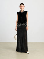 Front-facing model wearing a black silk velvet vest with ivory vine embroidery and sheer paneling.