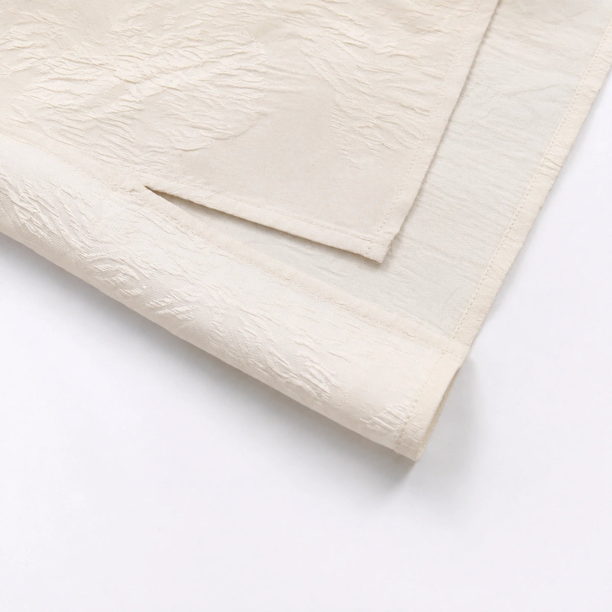 Close-up of the textured ivory silk fabric and refined woven pattern