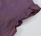 Close-up of the ruffled flutter sleeve and tone-on-tone jacquard pattern on luminous silk fabric.