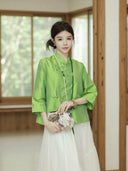 Model wearing a jade green Chinese-inspired silk top with straight sleeves and traditional closures