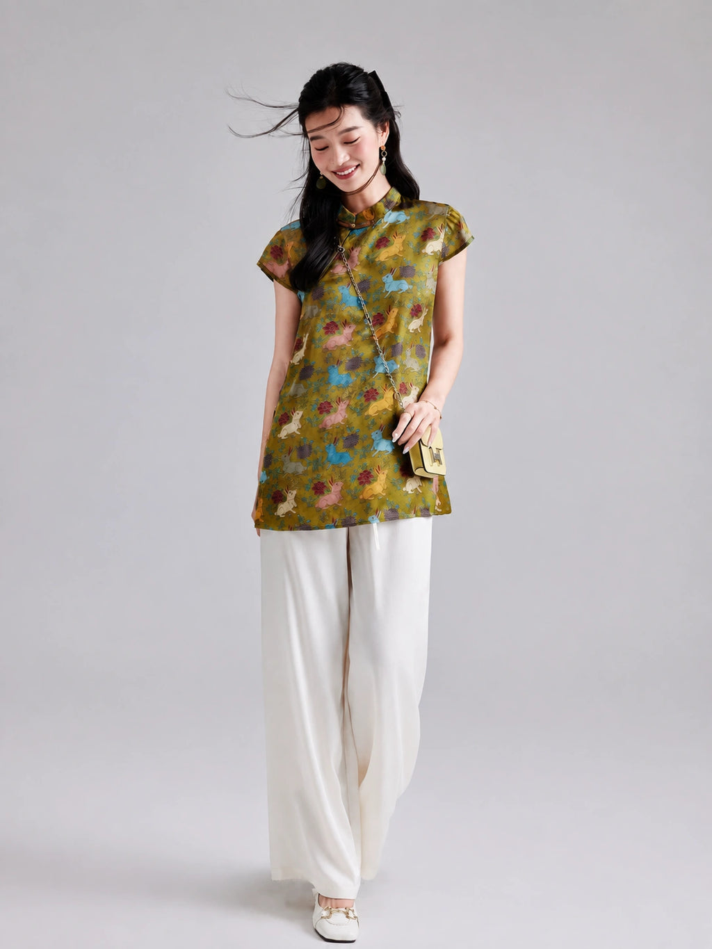 Model wearing a Gambiered Silk olive-gold rayon longline top with colorful rabbits and botanical motifs