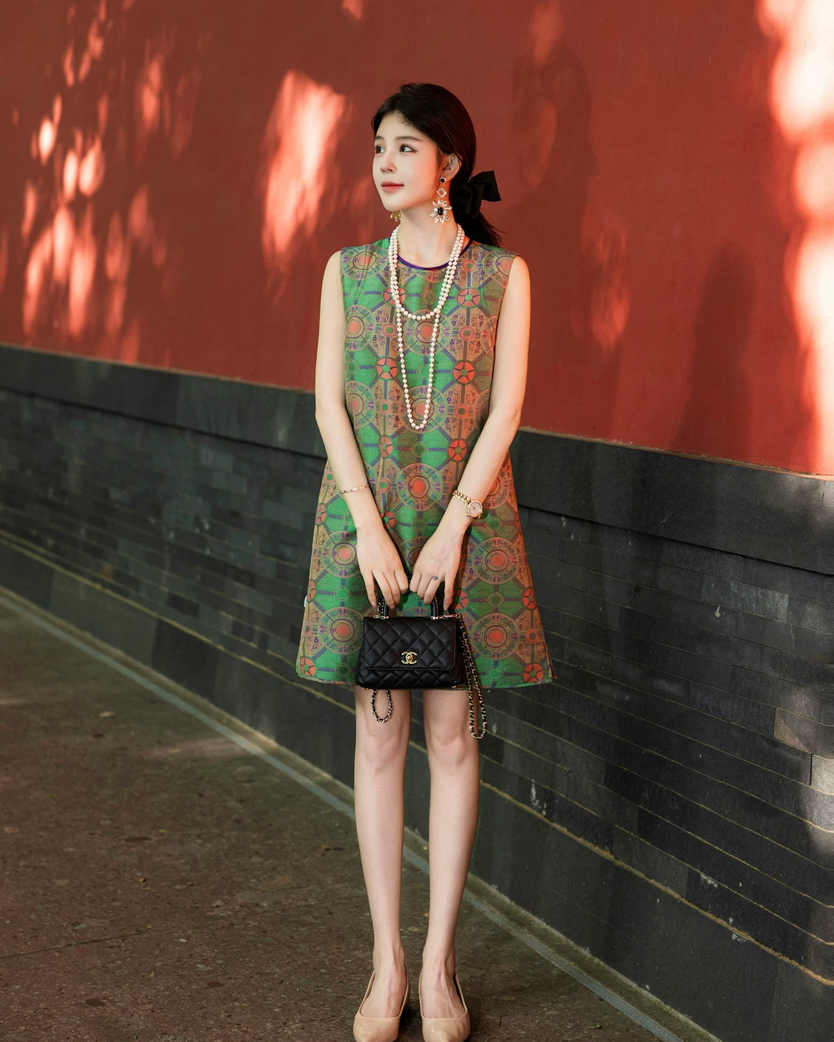 Model wearing a jade green multicolor Shu brocade sleeveless silk dress by Gambiered Silk.