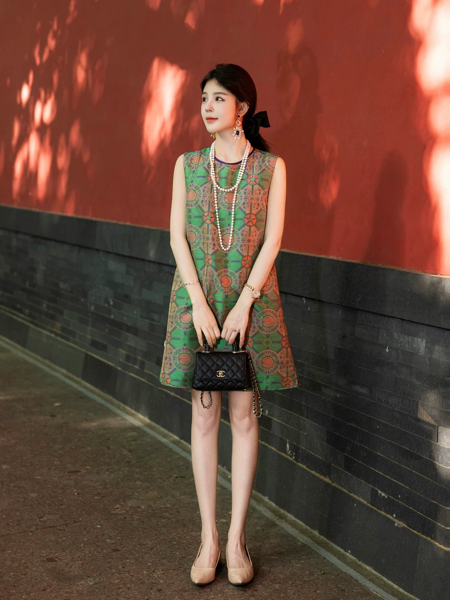 Model wearing a jade green multicolor Shu brocade sleeveless silk dress by Gambiered Silk.