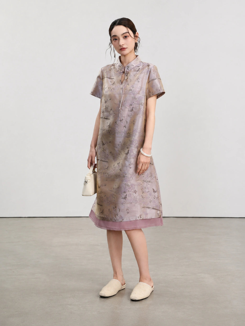 Three-quarter view of the light lavender silk qipao showing its softly flared A-line silhouette