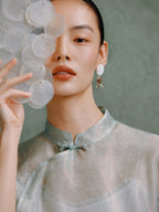 Close-up of the Mandarin collar and handcrafted frog button on the light celadon silk cheongsam top by Gambiered Silk.