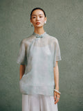 Light celadon silk cheongsam top for women by Gambiered Silk, front model view with modern Mandarin collar and relaxed fit.