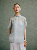 Light celadon silk cheongsam top for women by Gambiered Silk, front model view with modern Mandarin collar and relaxed fit.