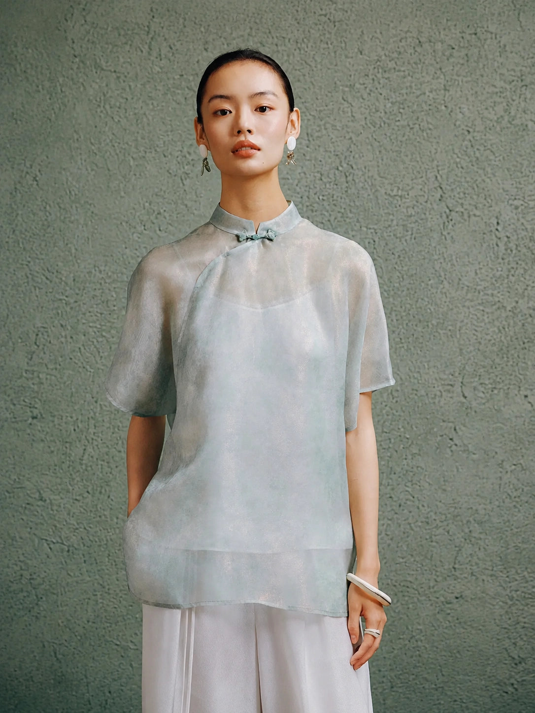 Light celadon silk cheongsam top for women by Gambiered Silk, front model view with modern Mandarin collar and relaxed fit.