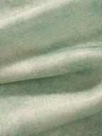 Close-up of the lightweight mulberry silk fabric with subtle sheen and soft texture used in the light celadon silk cheongsam top.