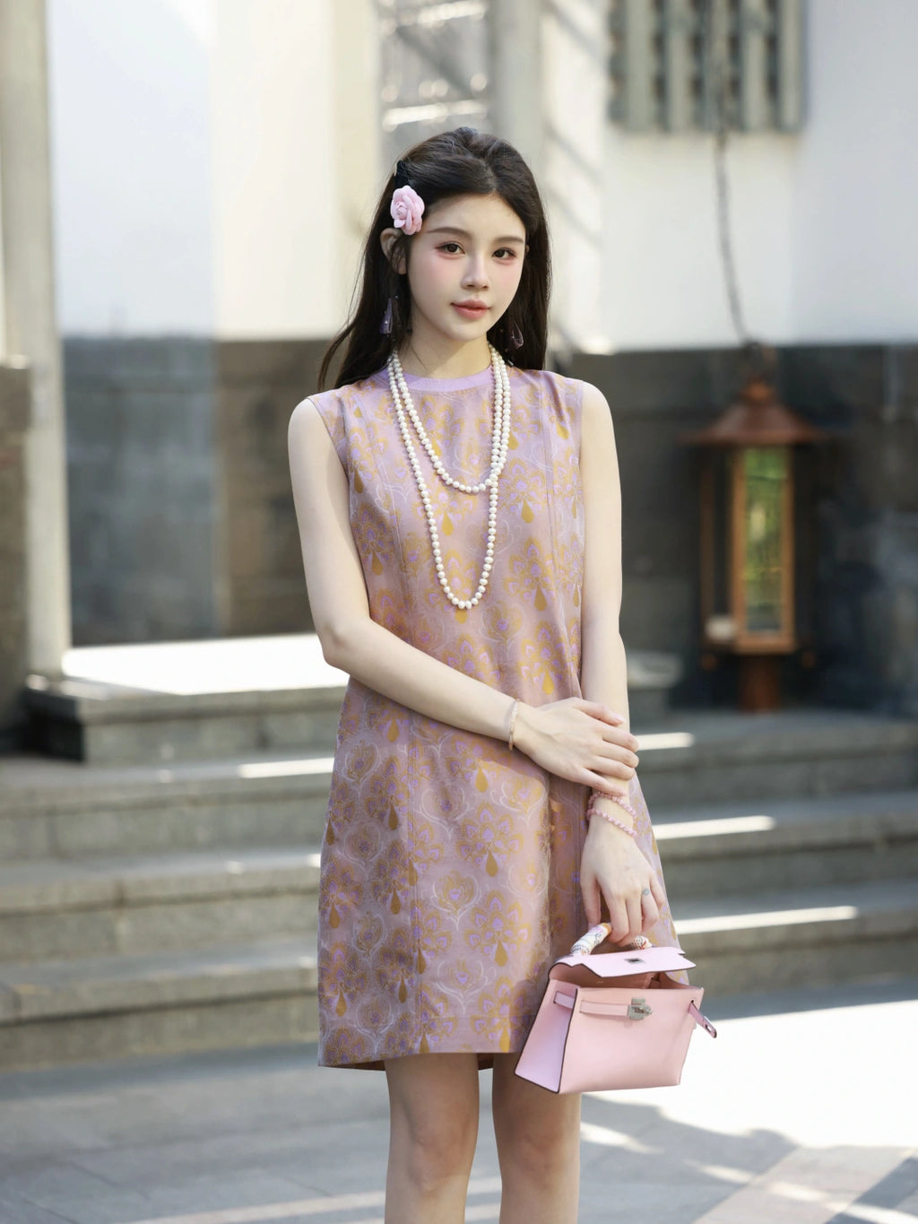 Front model view of a lilac-pink luminous brocade silk dress with golden floral motifs.