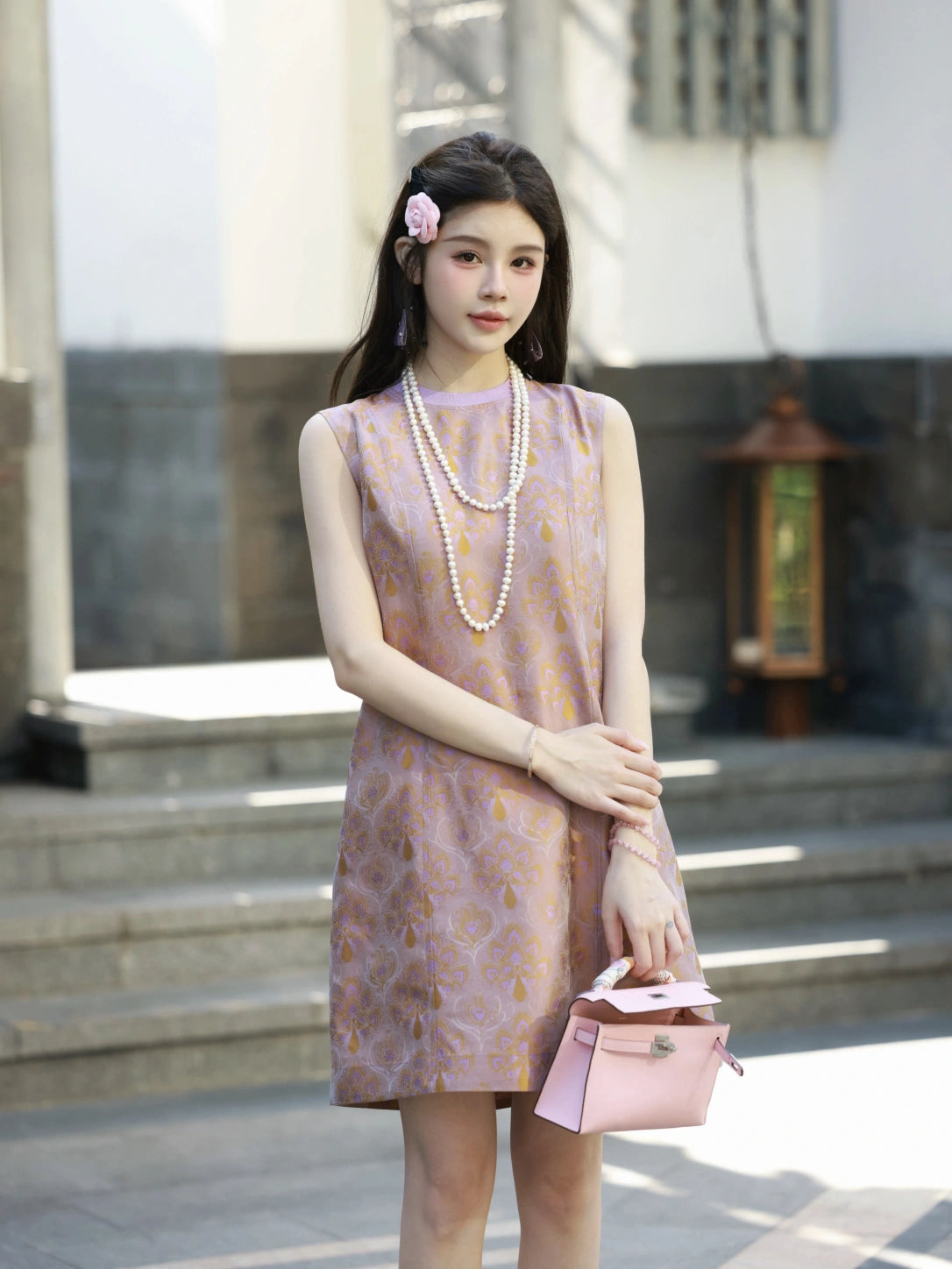 Front model view of a lilac-pink luminous brocade silk dress with golden floral motifs.