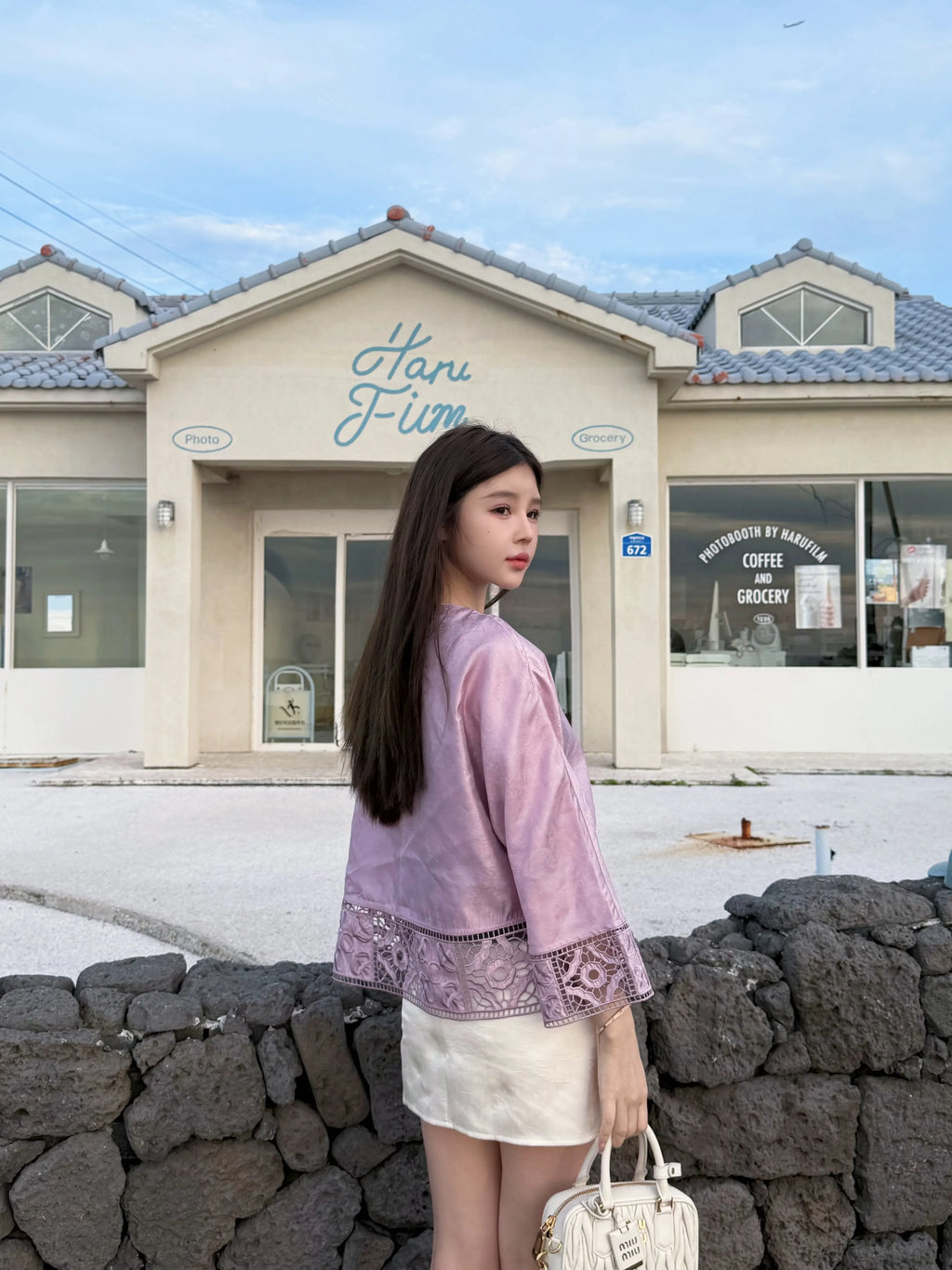 Back view of a rose pink silk jacket with openwork hem and straight sleeves