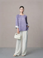 Elegant lilac mulberry silk blouse paired with white wide-leg trousers.