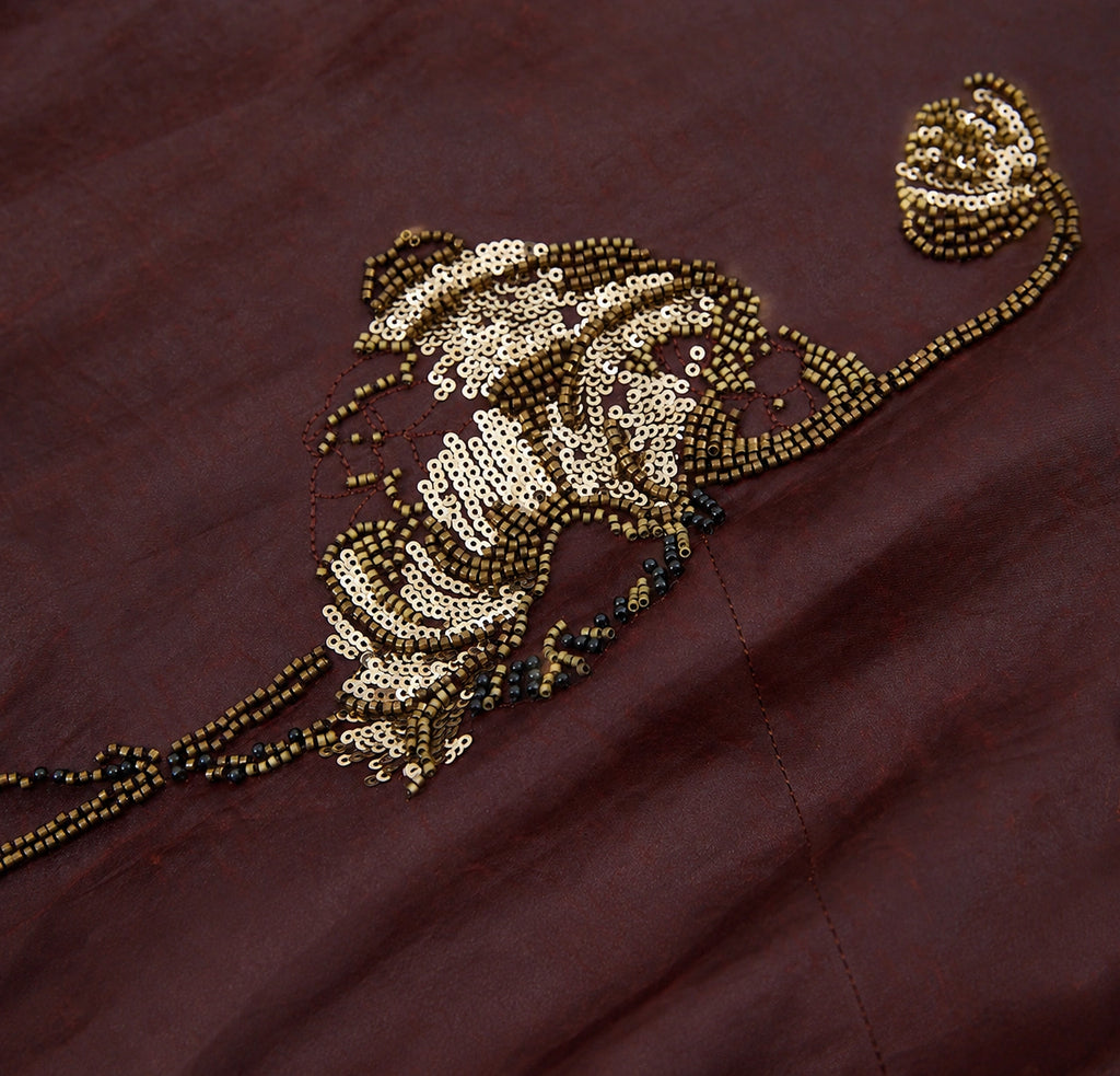 Close-up of the lotus-inspired motif embellished with bronze beads and shimmering sequins