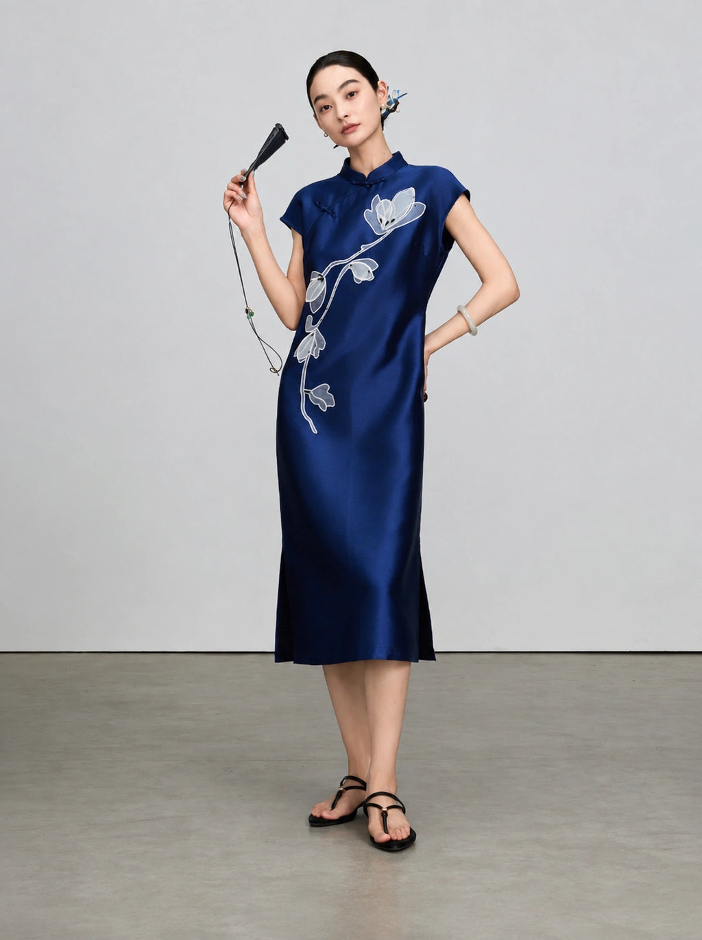 Full-length view of the navy sleeveless qipao with beaded magnolia embroidery