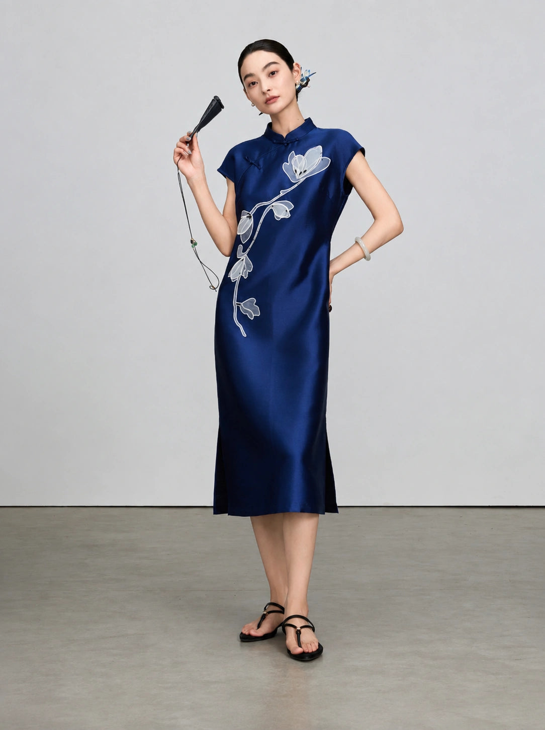 Full-length view of the navy sleeveless qipao with beaded magnolia embroidery