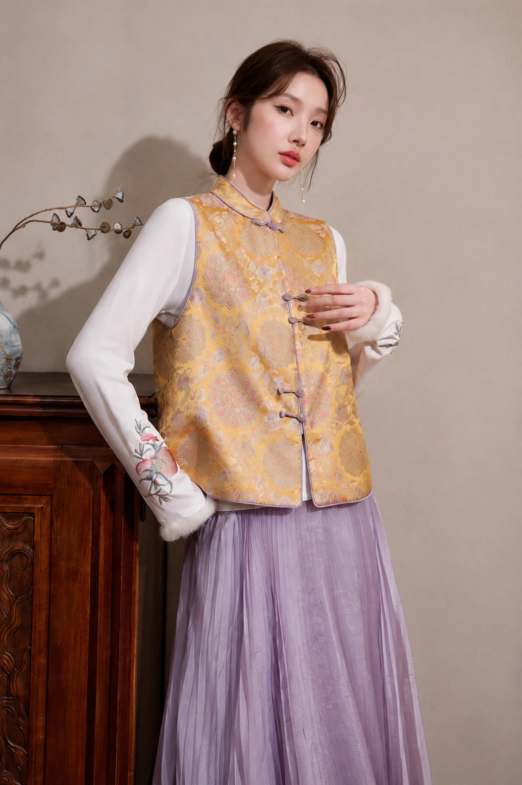 Model wearing the golden Mandarin collar brocade vest featuring lavender piping and handcrafted-style frog closures.