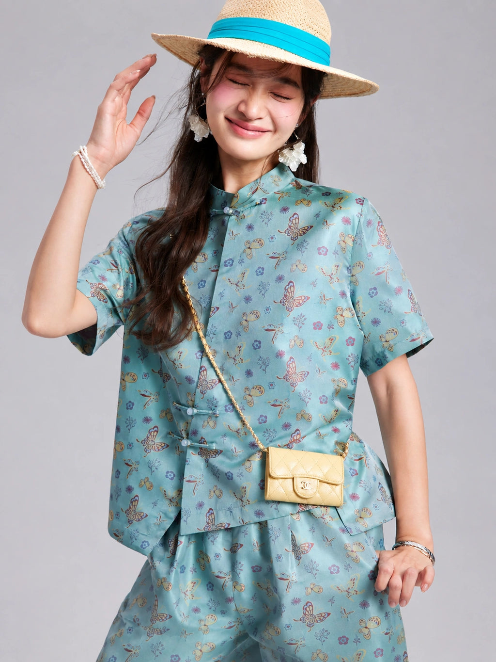 Close view of an aqua silk shirt with a Mandarin collar, short sleeves and knotted closures.