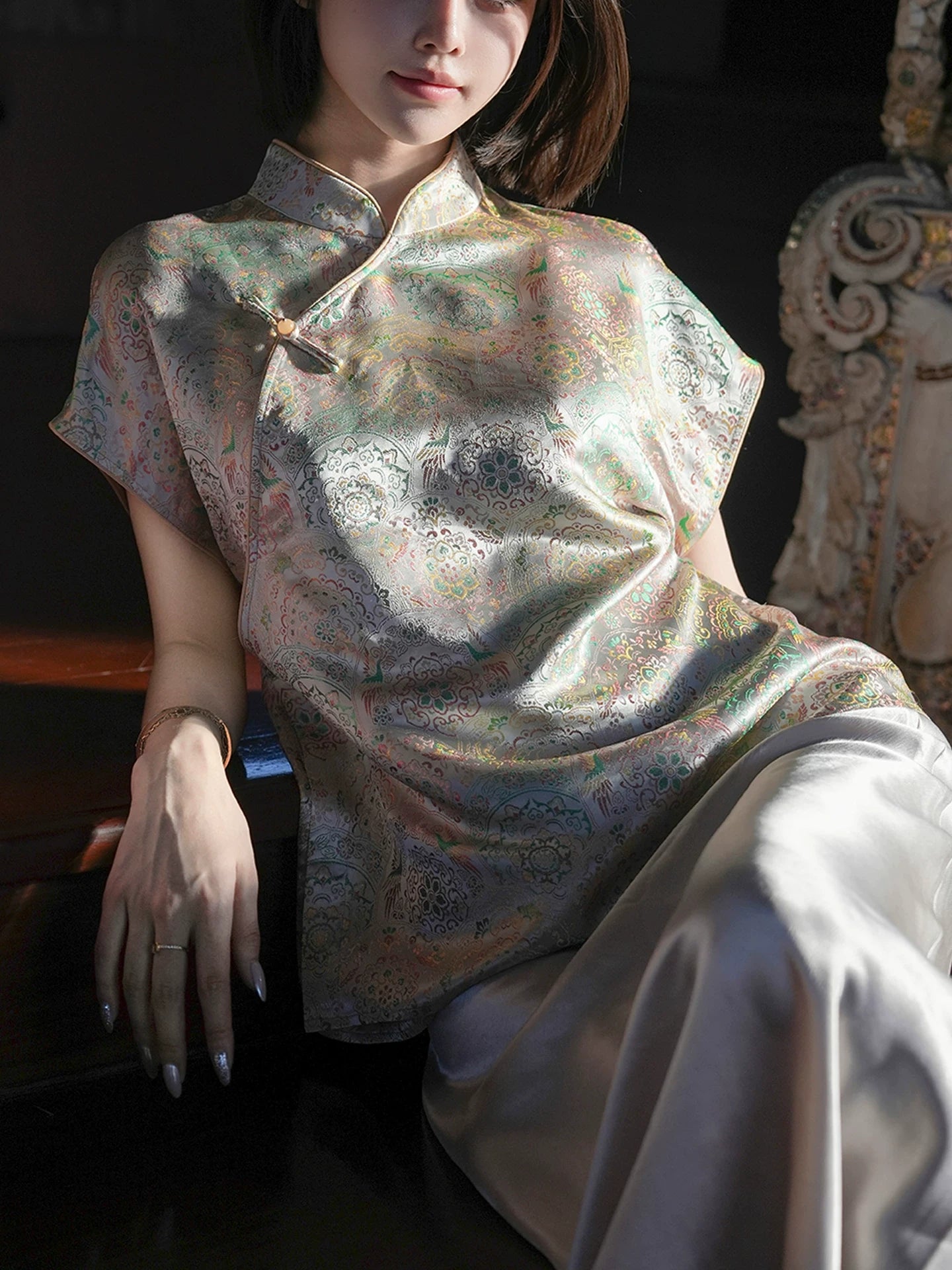 Close-up of the mandarin collar and decorative closure on a patterned silk-blend top