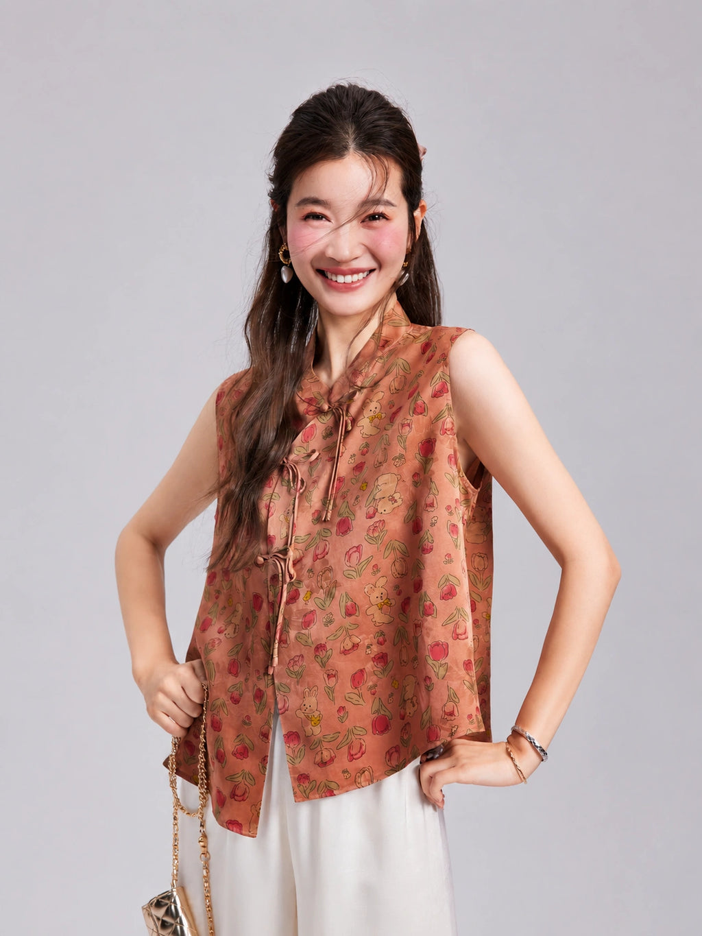 Model wearing a coral pink Gambiered Silk vest with a Mandarin collar, floral rabbit pattern and front opening