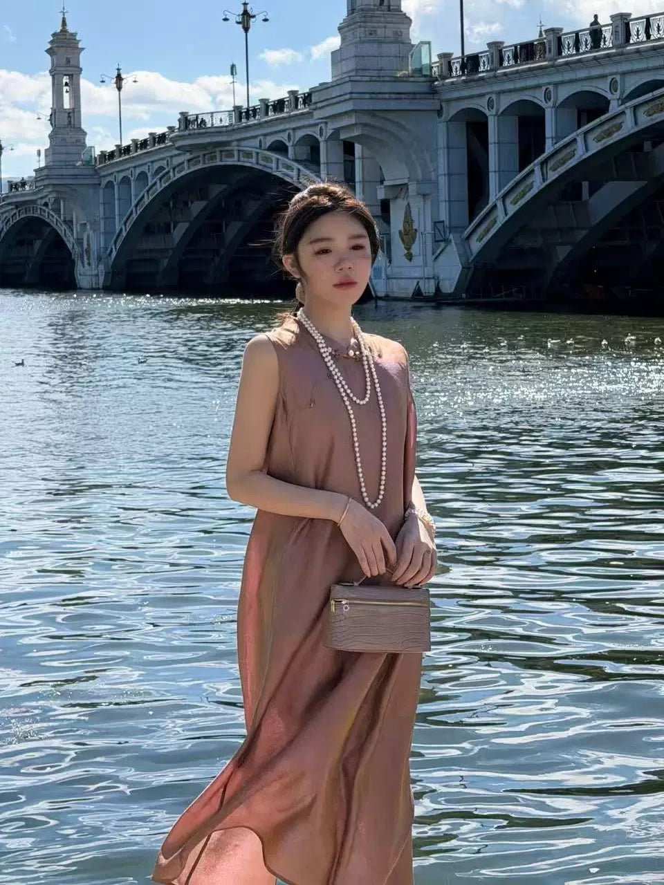 Model wearing a mocha brown 100% mulberry silk sleeveless H-line dress with a mandarin collar